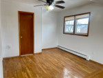 Large living room featuring hardwood floors and natural light in a two-bedroom apartment for rent.