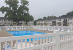 Outdoor swimming pool area with lounge chairs at Sterling Pointe Apartments, Monroe, MI