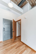 Entrance view of a 3-bedroom apartment in Woolen Mills Lofts, Appleton, showcasing hardwood floors and modern design.