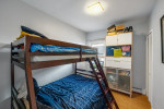 Cozy bedroom with a bunk bed, blue bedding, and storage furniture in a charming Brooklyn home.