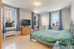 Spacious bedroom in a Brooklyn apartment with natural light, modern design, and a view of the street.