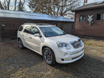 2012 GMC Acadia Denali in white with premium wheels parked outside, showcasing its sleek design and features.