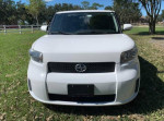 Front view of a clean 2008 Scion xB hatchback parked on grass, showcasing its modern design.
