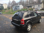2006 Hyundai Tucson Limited FWD parked, showcasing its sleek design and alloy wheels in a residential area.