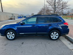 2011 Subaru Outback in blue, clean exterior, parked on a street, showcasing all-wheel drive capability.