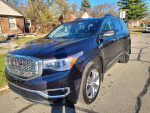 2017 GMC Acadia Denali FWD parked in a residential area, showcasing its sleek design and chrome grille.