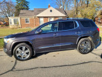 2017 GMC Acadia Denali FWD parked on the street, showcasing its sleek design and features.
