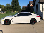 2011 Porsche Panamera in pristine condition with black wheels and red brake calipers parked outside a home