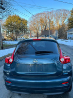 Rear view of a 2013 Nissan Juke SV AWD, suitable for sale with 59,000 miles, in a residential area.