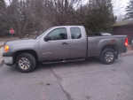 2012 GMC Sierra 4x4 Xtra cab WT in gray with 58,600 miles, parked on a road between trees.