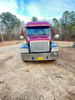 Front view of a 2002 Freightliner Century truck with a dump trailer, parked on a gravel road.
