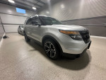 2013 Ford Explorer Sport AWD in silver, showcasing sleek design and premium features in a well-lit garage.