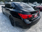 Black Infiniti Q50 sedan parked with a clear sky in the background, showcasing its sleek exterior design.