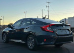 Rear view of a blue Honda Civic with moon roof and backup camera during sunset