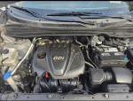Under the hood of a 2015 Hyundai Tucson GLS showcasing the GDi engine and battery configuration.