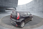 Side view of a 2015 Kia Soul in Shadow Black against a minimalist background, showcasing its modern design.