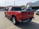 2014 GMC Sierra 1500 SLE in Fire Red, featuring a spacious bed and elegant design, with premium alloy wheels.