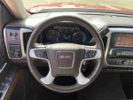 Interior view of a 2014 GMC Sierra 1500 SLE with V-8 engine, showcasing steering wheel and dashboard features.