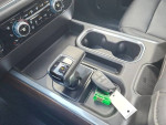 Interior view of 2023 GMC Sierra 1500 showing gear shift and cup holders.