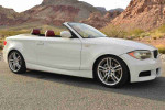 2013 BMW 135i Convertible in white with M Sport package parked in a scenic location.
