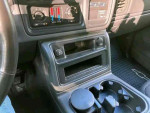 Interior view of the 2003 Chevrolet Silverado 1500 SS dashboard with controls and cup holders.