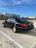 2004 Mercedes-Benz E320 with 69,727 miles in excellent shape, parked in a clean lot under blue skies.