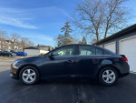 Side view of a 2014 Chevrolet Cruze 1LT Sedan parked, showcasing its sleek design and clean exterior.