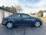 2014 Chevrolet Cruze 1LT sedan in black parked in a residential area, showcasing clean exterior and maintained condition.