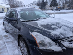 2012 Nissan Altima 2.5 FWD parked in snow, featuring clean title and low mileage, well maintained exterior.