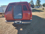 Rear view of a 2003 Ford F350 diesel truck with camper top and clean body in good condition.