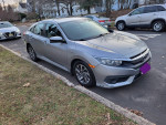 2016 Honda Civic EX FWD in silver parked on the street, showcasing its sleek design and side view camera.