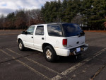 1999 Chevrolet TrailBlazer parked in a lot, showing exterior wear and tear, primarily rust