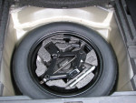 Compact spare tire and tools for 2012 Subaru Outback 2.5i AWD, stored in the trunk compartment.