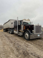1996 Peterbilt 379 truck with extended hood and new engine ready for trailers on a rural road.