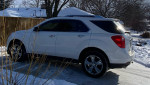 Side view of a 2015 Chevrolet Equinox LTZ in snow, showcasing its chrome wheels and sleek design.