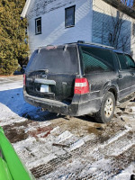 2010 Ford Expedition parked on snowy ground, showing wear and tear, suitable for eight passengers.