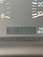 Odometer reading of a 2000 Jeep Cherokee XJ showing 223,050 miles with speedometer and trip reset button.