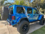 Blue Jeep Rubicon 392 parked in driveway, showcasing professional upgrades and garage-kept condition.