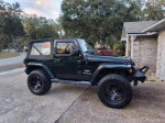 2012 Jeep Wrangler Sahara 4WD for sale, dark green exterior, lifted with aftermarket tires and soft top.
