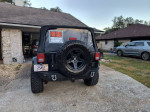 2012 Jeep Wrangler Sahara for sale with tinted windows, aftermarket tires, and black soft top.