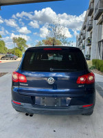 Rear view of a 2011 Volkswagen Tiguan in good condition, parked outside with clear blue sky.