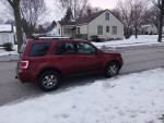 Red Ford Escape 4x4 parked on a snowy street, featuring good tires and no visible issues.
