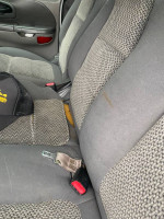 Interior seats of a 2002 Ford F-150 quad cab with minor wear and a hat resting on the side