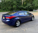 2011 Hyundai Elantra GLS in blue, parked with trees in the background, showcasing its sleek design and well-maintained exterior.