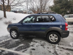 2005 Hyundai Tucson 4x4 with Bluetooth stereo, backup camera, and clean interior, parked in snowy area.