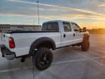 2009 Ford F250 Superduty Lariat with 6-inch lift and custom wheels parked at sunset