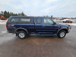 2002 Ford F-150 truck in blue color parked with a cap, low mileage, well-maintained from previous owner