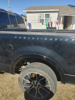 Side view of a 2006 Ford Harley Davidson truck with aftermarket wheels and visible wear.