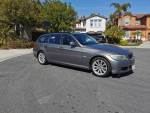 2011 BMW 3 Series wagon in gray parked on a residential street, ideal for families and sports enthusiasts.