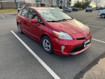 2012 Toyota Prius Five Hatchback in excellent condition, red color, parked in a lot, well-maintained and fuel-efficient.